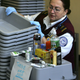 A security screener stacks trays at a security checkpoint at Logan International Airport in Boston.